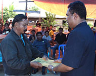 Ketua Komisi IV DPRD Kukar H ALi Hamdi (kanan) menyerahkan bantuan kepada perwakilan keluarga korban