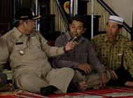 Wabup Samsuri Aspar memperdengarkan pesan Bupati Syaukani dari ponselnya di hadapan warga Muara Wis