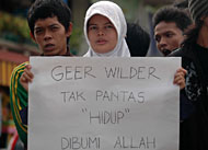 Salah seorang gadis membentangkan poster kecaman terhadap Geert Wilders