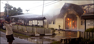 Seorang bocah berusaha melempar batu ke arah Kantor Departemen Agama Kukar yang tengah dilalap si jago merah, Selasa (11/04) sore