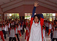 Seorang instruktur tengah memperagakan Senam Cerdas Ceria diatas pentas sambil diikuti para peserta diklat SCC