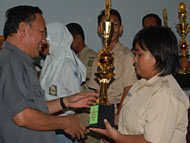 Waka Disdik Kukar H Abd Thalib menyerahkan trofi kepada siswi SMAN 1 Tenggarong, Rina Zubaidah, yang meraih gelar Juara I bidang Fisika