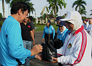 Sekkab Husni Thamrin menyerahkan bibit pohon kepada salah seorang anggota DWP Kukar