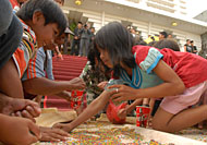 Beberapa bocah mengumpulkan beras Tambak Karang yang tersisa ke dalam gelas plastik