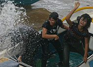Tiga orang gadis membalas siraman ke arah mereka dengan melemparkan kantong berisi air