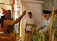 Seorang Belian (kiri) melakukan <i>tepong tawar</i> terhadap Sultan Kutai dalam upacara Beluluh
