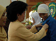 Penasehat GOPTKI  Ny Hj  Farida Samsuri Aspar memasang tanda peserta secara simbolis pada pembukaan Workshop KTSP TK