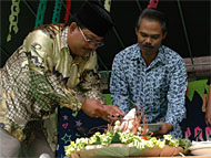Drs Yasir MM (kiri) didampingi Ketua Panitia M Yamin saat melakukan pemotongan tumpeng