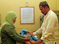 Salah seorang petugas Puskesmas Rapak Mahang (kiri) ketika mengkhitan seorang bocah