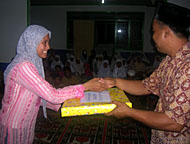 Ketua KOPRI Kukar Santi Mariyana menyerahkan bingkisan kepada pimpinan Ponpes & Panti Asuhan Mishbaa Hun Muniir Didi Syahrianto