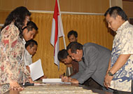 Ketua KPU Kukar Rinda Desianti (kiri) menyaksikan penandatanganan kesepakatan bersama oleh ketiga timses