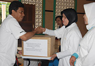 Ketua DWP Kukar Ny Hj Innayati menyerahkan bantuan secara simbolis kepada Sekcam Loa Janan