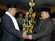 Wabup H Samsuri Aspar (kiri) menyerahkan piala tetap Juara Umum kepada pimpinan Kafilah Tenggarong