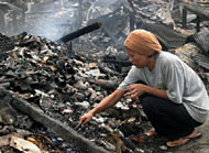 Seorang ibu mengawali pagi 2008 dengan mengais puing-puing sisa kebakaran