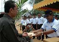Camat Muara Jawa Kasran Hamid (kanan) menyerahkan secara simbolis bantuan korban banjir kepada Asisten I Pemkab Kukar HA Ridwan Sya'ranie