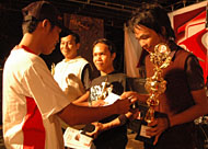 Perwakilan sponsor menyerahkan trofi Band Terbaik I kepada gitaris Chromatics, Yanda