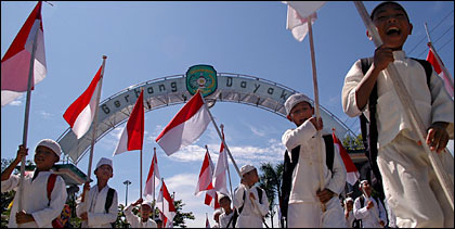 Keceriaan para pelajar SD sambil membawa bendera Merah Putih dalam Pawai Taaruf Tahun Baru 1429 H