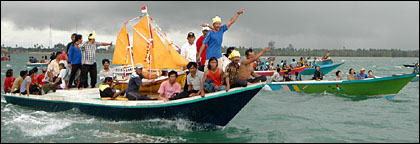 Diiringi puluhan kapal nelayan, perahu kecil berwarna kuning yang berisi aneka macam sesaji dibawa ke laut lepas