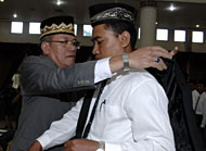 Ketua Panwas Pilkada Kaltim Hatta Zainal memasangkan atribut secara simbolis kepada salah seorang petugas Panwascam yang baru dikukuhkan