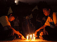 Para kader PMII melakukan aksi menyalakan lilin di halaman Kantor PLN Ranting Tenggarong