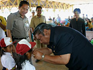 Wabup Samsuri Aspar ketika memasangkan kacamata minus bantuan dari Diskes Kukar dan IKBJ Tenggarong untuk pelajar dari keluarga tidak mampu di Rapak Lambur