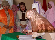 Ketua DWP Kukar diwakili Ny Hernawati Bahrul saat menandatangani berita acara pengukuhan pengurus Salimah Kukar