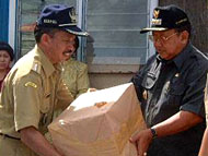 Pj Bupati Kukar Hadi Sutanto (kanan) saat menyerahkan bantuan kepada Camat Sebulu H Erlian