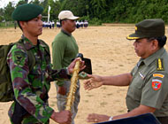 Staf Ahli Pangdam VI/Tanjungpura Kolonel CZI Atmadi Mulyono (kanan) menyerahkan cangkul secara simbolis kepada seorang prajurit TNI