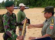 Staf Ahli Pangdam VI/Tanjungpura Kolonel CZI Atmadi Mulyono (kanan) menyerahkan cangkul secara simbolis kepada seorang prajurit TNI