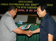 Ketua Umum LPJK Kaltim Ir Benni Dhanio (kanan) saat menyerahkan lambang organisasi LPJKD dan buku petunjuk kepada Pj Bupati Kukar Drs Hadi Sutanto