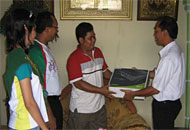 Kakancatel Tenggarong, Zulpan Wardhana, menyerahkan hadiah laptop kepada Anjas (tengah)