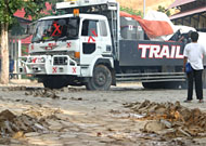 Kerusakan lapangan dalam kampus Unikarta akibat dilintasi trailer, sementara trailer tak dapat bergerak lagi karena amblas