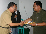 Kabag Humas Kukar Abidinsyah Kadrie (kiri) menyampaikan materi workshop secara simbolis kepada Kepala SMAN 1 Tenggarong Drs Yasir MM